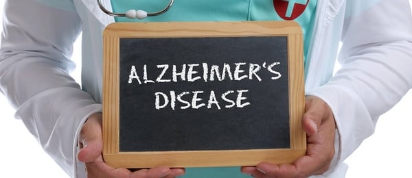 Medical doctor holding a chalk board with the words Alzheimer's disease.