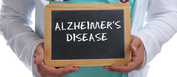 Medical doctor holding a chalkboard with Alzheimer's disease written.