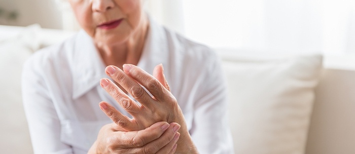 Older woman holding her hands in pain.